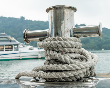 无线电帆柱在美丽的绿水上停靠在小船上的泊位绳索金属海军码头电缆港口水手运输对接航海背景