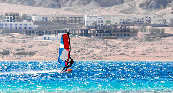达哈卜一名在埃及红海乘着彩色帆帆的冲浪者冒险蓝色娱乐运动员支撑旅游岩石山脉男人冲浪背景