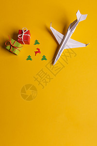 圣诞折纸一组纸机朝一个方向走 一人用不同的方式指向黄色背景 圣诞树枝 礼物和礼品 笑声 1月1日喷射竞赛飞机商业天空成功旅行白色领导红色背景