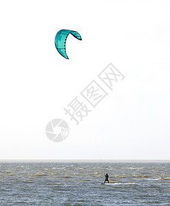 在海浪上漂浮着运动员冲浪者活力风筝空气男生锦标赛木板绿色背景图片