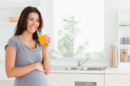 好漂亮的孕妇 站着时喝杯橙子汁的好眼熟的孕妇高清图片