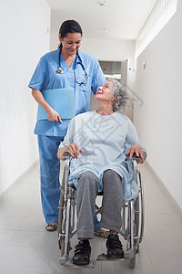 坐在轮轮椅上看护士的老年病人背景图片