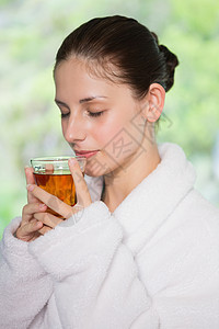 白色浴袍浴袍中美丽的女人在喝茶浴衣女性玻璃头发黑发眼睛热饮闲暇白色背景