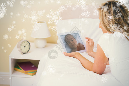 纸片雪花利用躺在床上的平板纸片的女人触摸屏长发快乐床头柜计算机下雪男性房子头发新生背景