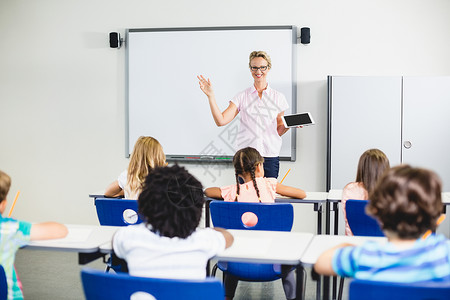 班级数字素材教师在数字平板电脑上教孩子男生学习技术教育女孩混血班级女性童年休闲背景