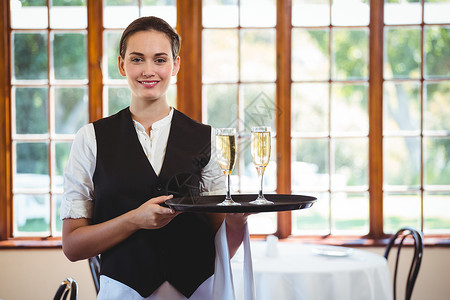 香槟女人拿着香槟长笛托盘服务女服务员的肖像职业酒店工人酒精茶点微笑工作餐厅女士款待背景