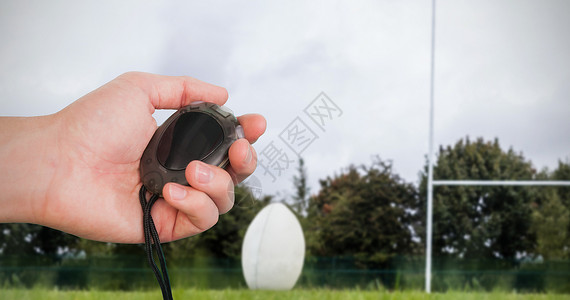 握着时钟计的手贴近绿色运动闲暇邮政跑表门球速度行动播放器橄榄球背景图片