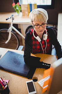 绘图板从事计算机工作的女性图形设计师职业休闲监视器办公桌电脑金发女郎眼镜技术创造力商业背景
