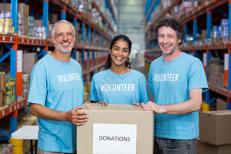 快乐的志愿者笑着 用捐赠箱装扮高清图片