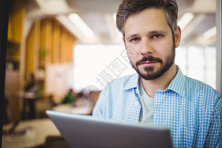 办公室使用数字平板电脑的商务人士肖像休闲男人胡子商务药片技术公司职业服装微笑背景图片