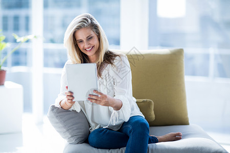 年轻妇女在家里使用数字平板电脑微笑家庭生活房子家庭触摸屏公寓窗户沟通闲暇休闲背景图片