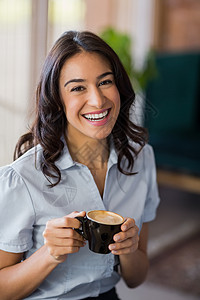 微笑着的女人喝咖啡的肖像桌子快乐喜悦女士女性茶托商业商务会议酒店背景图片
