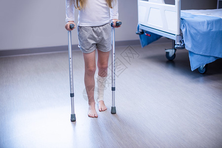 跛行女孩在病房中带着拐杖走路女性医院互动住院休闲医疗保健疼痛医务室病人背景