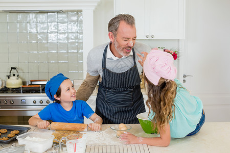 一位父亲和女儿父亲和孩子在厨房挣钱时玩得开心背景
