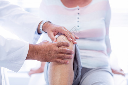 向高龄妇女提供膝膝治疗的理疗师专家肌肉医院身体理疗按摩师疼痛咨询卫生医疗背景图片