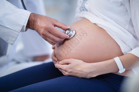 医生在病房用听诊器检查孕妇肚子腹部实验室服务女性卫生访问孕妇装职业专家孕产怀孕背景图片