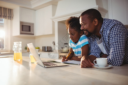 一位父亲和女儿父亲和女儿在喝咖啡时使用笔记本电脑背景