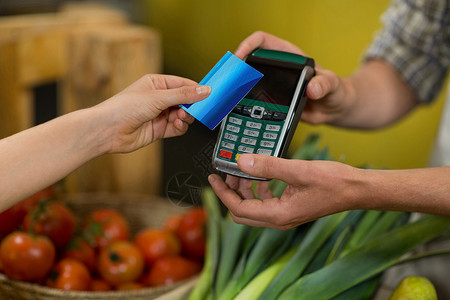 支付中素材妇女在杂货店使用NFC技术付款妇女利用NFC技术付款支付团队近场市场零售服务快乐设备店铺通信背景