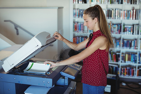 在图书馆使用Xerox影印机的在校女生高清图片