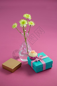 并列关系图花花花瓶和纸杯蛋糕 带有粉红背景的礼品盒背景