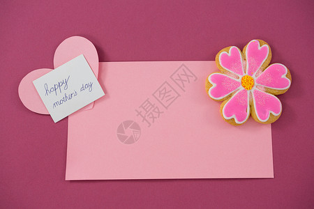 花形饼干 红信封上的心形卡 粉红背景背景图片