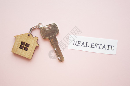 明亮粉红色的木制房子玩具和银钥匙标题住宅木头财产金融销售商业代理人保险安全背景图片