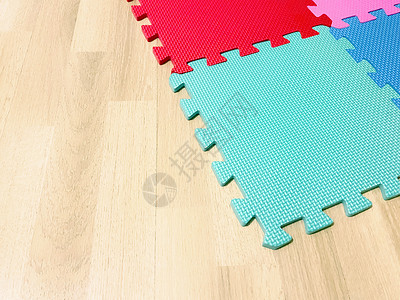抽象瑜伽素材由彩色块组成的软橡胶垫在木地板上相互交叉房子正方形婴儿厚度组装新生地板风格家庭生活游戏室背景