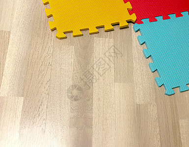 嵌入式教育Linux由彩色块组成的软橡胶垫在木地板上相互交叉操场瑜伽橡皮新生组装装饰家庭生活正方形地板孩子背景