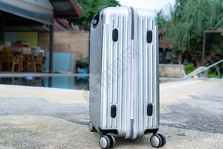 银色旅行行李已经准备好去夏季海滩和游泳池背景图片