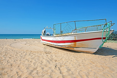 阿尔加韦海滩上的老渔民船渔船海洋海滩村庄钓鱼海浪运输背景图片