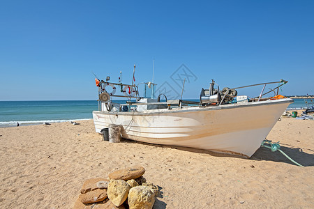 阿尔加韦海滩上的老渔民船海洋海浪渔船钓鱼村庄运输海滩背景图片