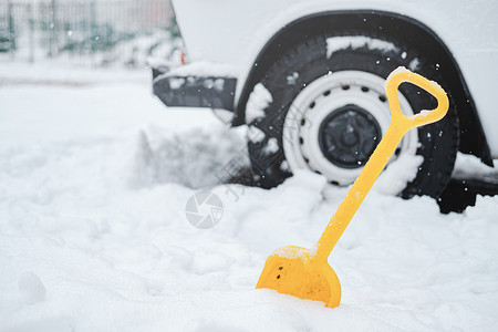 雪中的车轮和铁铲 冬季交通问题的概念高清图片