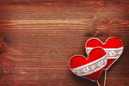两颗心带着鞋带 爱情的象征 木质背景 适合情人节卡片 文本位置假期毛毡蕾丝红色手工庆典工艺情感织物背景图片