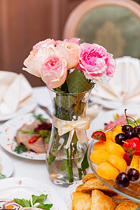装饰玫瑰花朵的盛宴餐桌 花卉装饰品加高处花瓶装饰背景图片