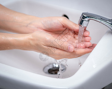 7步洗手女人在浴室里用自来水洗手 手清洁下背景