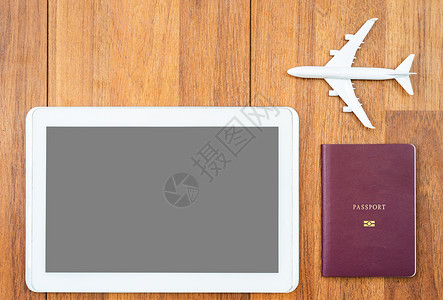 数字平板机和护照放在办公桌上的飞机背景图片