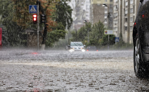 滂沱路面和人行道的水车站在十字路口 有暴雨背景