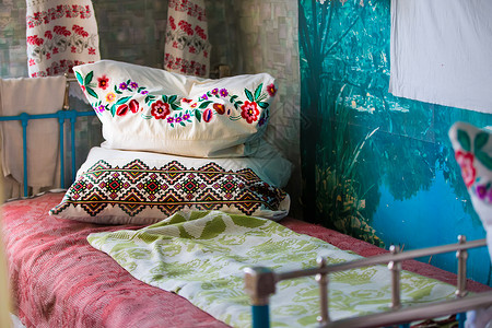 带绣花靠垫的古铁床 带枕头的旧铁床 旧 be 上的绣花枕头背景