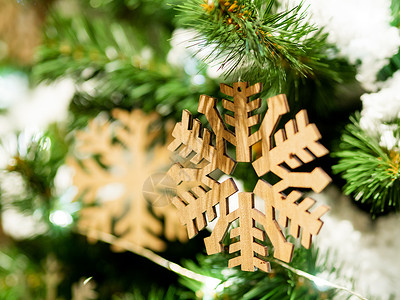 圣诞节和新年乡村装饰圣诞树上的木制雪花与灯泡生态雕刻绿色工艺假期庆典针叶手工手工业喜悦背景图片
