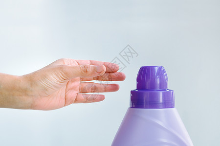 柔软剂使用液体洗衣软化剂洗涤衣物的妇女手液体厨房毛巾女士肥皂机器塑料织物洗衣店护发素背景