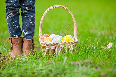 草绘关紧的篮子 充满了儿童手中的丰富多彩的复活节鸡蛋打猎庆典假期孩子节日乐趣童年活动草地家庭背景