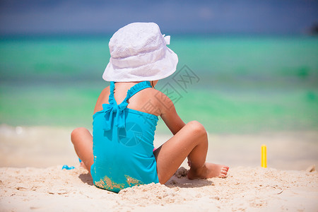 可爱沙堡在沙滩度假期间玩玩具的可爱小姑娘游泳衣海岸海滨闲暇支撑沙堡青年海洋海岸线喜悦背景