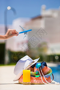飞机包素材暑假时 女性手上的多彩海滩袋 果汁杯 草帽和飞机模型旅行闲暇旅游空气情调太阳镜稻草蓝色帽子游泳背景