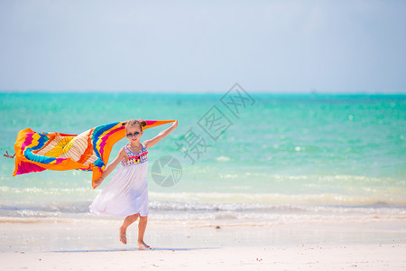 可爱的小孩在热带沙滩上和帕瑞奥跑起来玩得开心高清图片