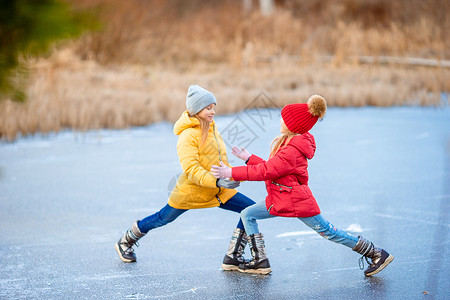玩抽冰尜女孩冬季雪日 适女女孩在寒冷的冰场露天溜冰婴儿速度孩子企鹅套装女儿运动衣服溜冰者溜冰场背景