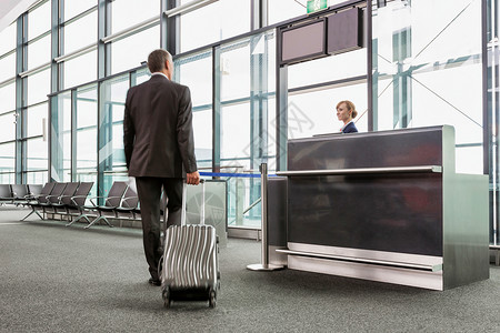 在机场登机的大门上携带行李箱行走的成熟商务人士的近视景象畅销书套装下载职业飞机护照游客飞行次数国际背景