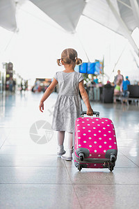 开着粉红色年轻的可爱小女孩的肖像 带着粉红色手提箱在机场跑来跑去旅行粉色飞机场手提闲暇跑步国际飞机女孩航班背景