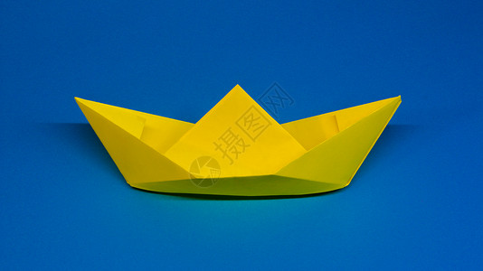 蓝色折纸标签折纸黄色纸船在蓝色背景