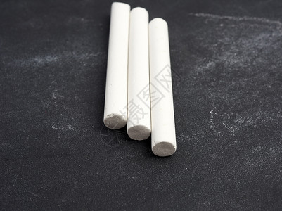 班级活动策划表黑色表面上的三支白色粉笔背景
