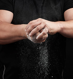 滑石穿黑色制服的肌肉运动运动员用白色DR擦手粉末健美面粉身体成人力量手指粉笔训练男性背景
